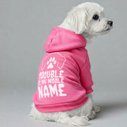 Maltese dog wearing a 'Trouble Is My Middle Name' hoodie